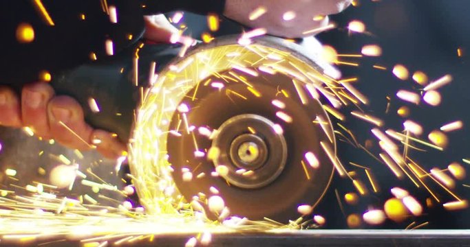 locksmith with a laser cuts in half a sheet of steel causing sparks.The laser heat Nicks iron up to get clean cuts and perfect for buildings with wrought iron.Concept: industry,technology,engineering.