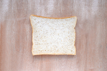 Sliced whole wheat bread on wooden background.