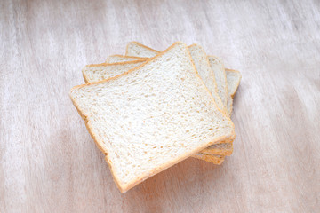 Sliced whole wheat bread on wooden background.