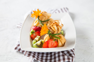 pancake sacks with a cottage cheese and fruit stuffing in a plate on a table, selective focus, copy space