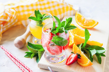 drinks with strawberry and orange in a glass on a table, selective focus