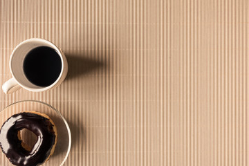 Top view of coffee cup with donut on table. Free space for text