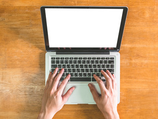 Top view of Male hands using Laptop with blank screen on wooden table