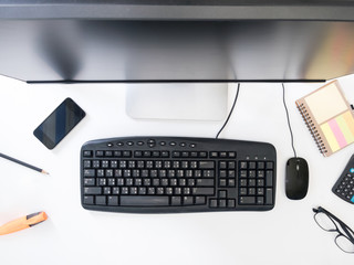 Top view of Desktop computer with office supplies on white background