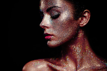 Portrait of beautiful woman with sparkles on her face. Girl with art make up in color light....
