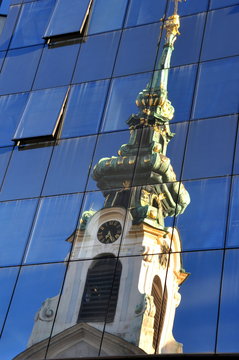Turm der Schottenkirche im Spiegelbild einer Glasfassade