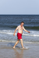 handsome man walking at the  beach