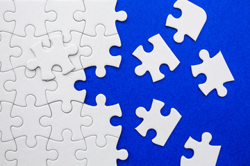 White puzzle elements on a blue background.  - obrazy, fototapety, plakaty