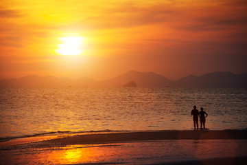 Fototapeta na wymiar Seascape, beautiful sunset beach with silhouette couples togethe