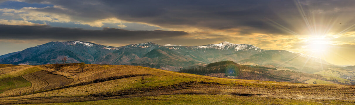 panorama of rural fields in mountains at sunset