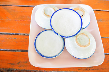 A Set of Khnom Tuay, or Thai Coconut Milk Custard, on a Wooden Table