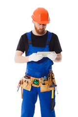 Man builder in the uniform with a tablet in the hands