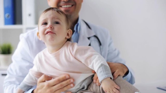 smiling doctor with baby at clinic