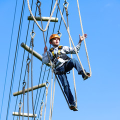 Happy child, healthy teenager school boy enjoying group friends activity in a climbing adventure park on a sunny spring or summer day