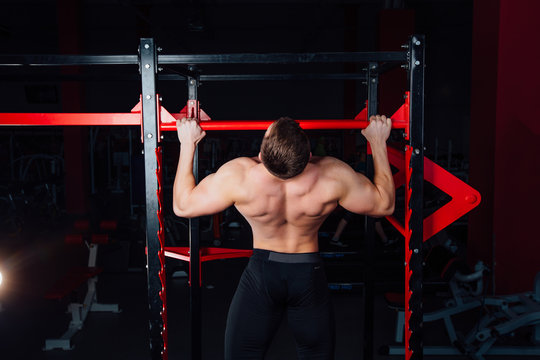 Strong man doing pull ups handsome athlete at gym. big confident muscular  training.