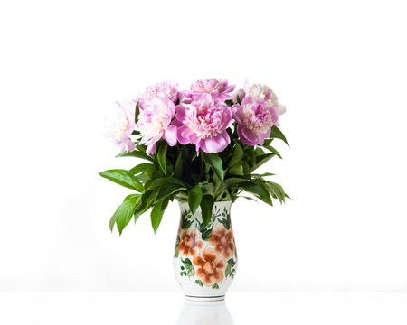 Bouquet of beautiful  pink peony flowers in decorative rustic style pot. Floral design wallpaper