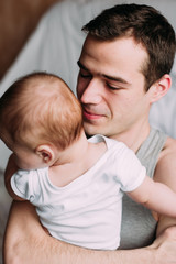 Portrait of loving father with baby boy 4-6 months his son at ho