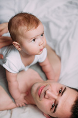 Portrait of loving father with baby boy 4-6 months his son at ho