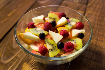 Delicious fruits salad in plate on table close-up