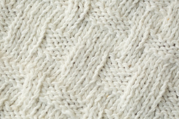 Knit texture of white wool knitted fabric with cable pattern as