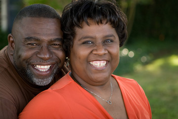 Mature African American couple laughing and hugging.