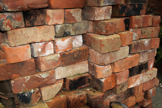 Old reclaimed building bricks from demolished building stacked for sale or reuse.