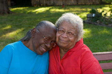 Happy mature African American sisters laughing and smiling.