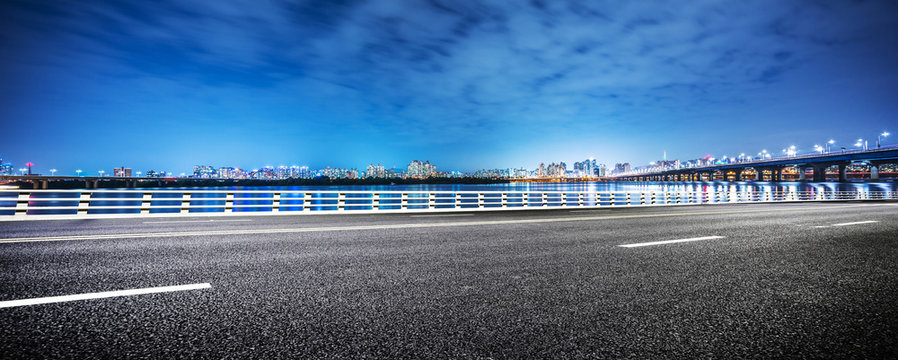 empty asphalt road and modern bridge in seoul at night