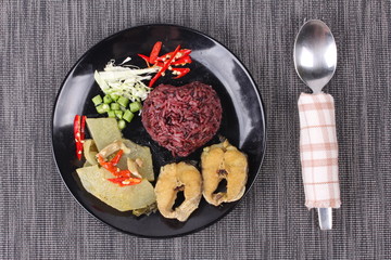 Brown jasmine rice topped green chicken curry and fish.