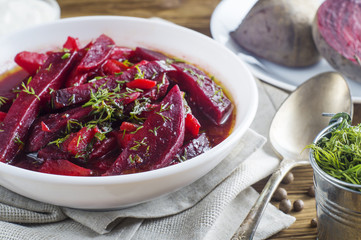 Vegetable soup - red borsch  in a white bowl on a rustic wooden background, clouse up. Healthy beetroot soup, vegetarian food. Delicious beet soup with dill.