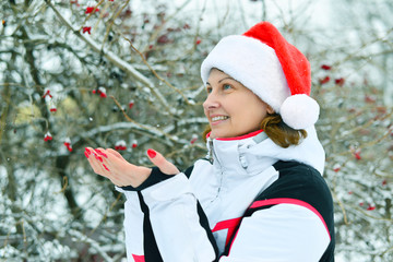 Woman in cap Santa Claus on background of Viburnum