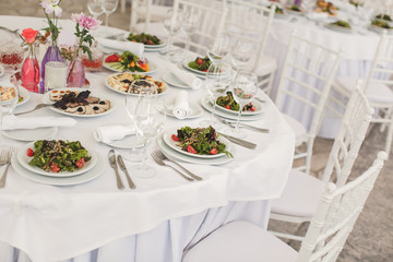 The inside of a massive white wedding tent with tables and chair