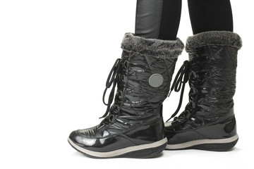 Female legs in black winter boots, isolated on white background.