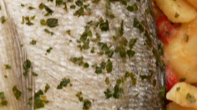 Closeup of Gilt-head bream fish ready to cook with parsley, pepper and potatoes.
