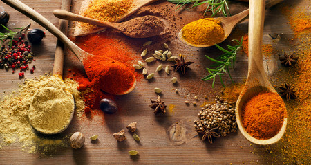 Various spices on wooden board.