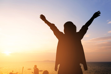 Fototapeta premium silhouette woman hands up at the beach