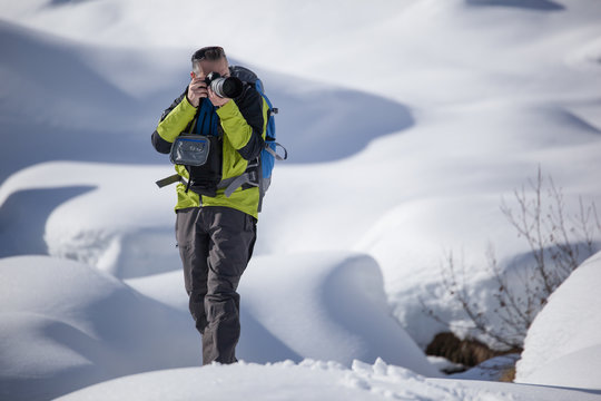 Fototapeta Fotografo con macchina e teleobiettivo nella neve