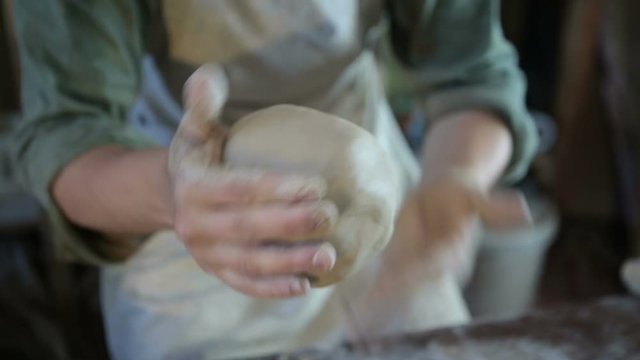 Potter works with clay. Making pots and other products