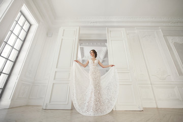 Beautiful bride posing in wedding dress in a white photo Studio.