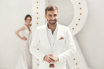 Chic wedding couple groom and bride posing in a white Studio. Ha