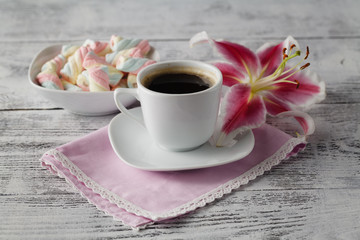 Sweets with coffee and lily flower on table