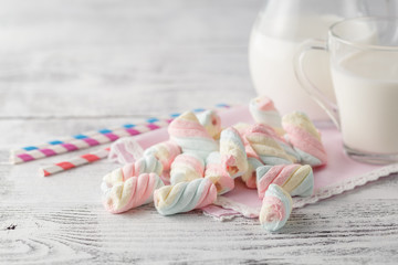 Pile of american twisted marshmallow on table with glass of milk