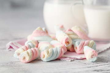 Pile of american twisted marshmallow on table with glass of milk