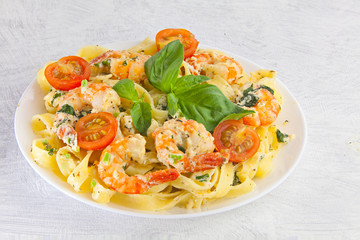 delicious fettuccine pasta with prawns on white plate