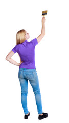 Back view of a girl who paints the paint roller. rear view people collection. backside view of person. Isolated over white background. 