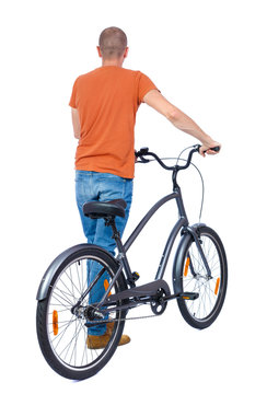 back view of a man with a bicycle. Cyclist keeps the wheel of a bicycle. Rear view people collection.  backside view of person. Isolated over white background. The guy in a T-shirt is a bicycle.