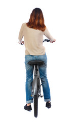 back view of a woman with a bicycle. cyclist sits on the bike. Rear view people collection.  backside view of person. Isolated over white background. Brunette on the bicycle looks away.
