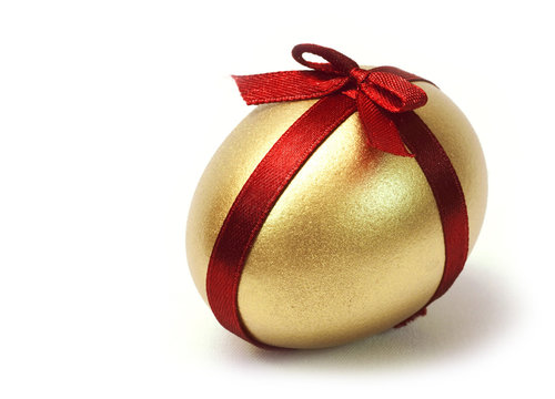 Easter Gold egg with red ribbon cross and bow on white background isolated.