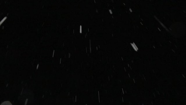Heavy wet snow falling in winter plate, tilted (4K). Shot for compositing over footage. Use with blending mode (add / screen) to remove the dark background or use as matte. Shot 1/50 for motion blur. 