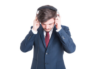 Business man standing looking down and putting on headphones